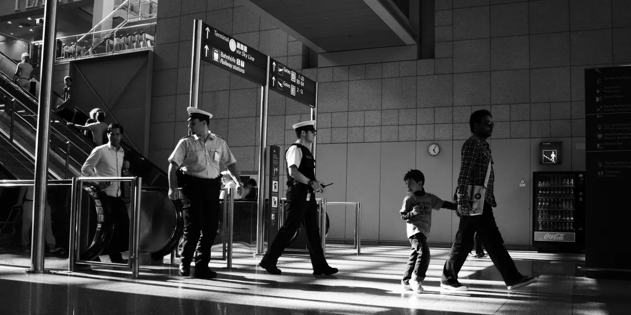 Polizisten an einer Bahnhofsrolltreppe, die sich umschauen.