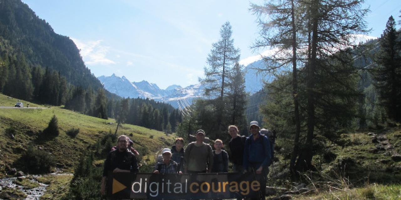Die Münchener Ortsgruppe bei einer Wanderung in den Bergen. Sie halten ein Digitalcourage-Banner in den Händen.