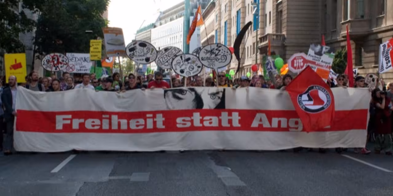Demonstrant.innen einem riesigen „Freiheit statt Angst“-Banner.