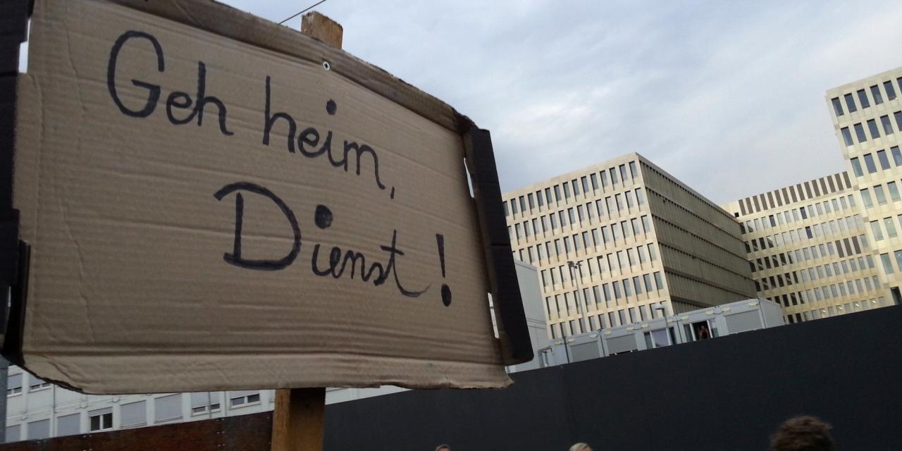 Demoschild mit dem Text: „Geh heim, Dienst“.
