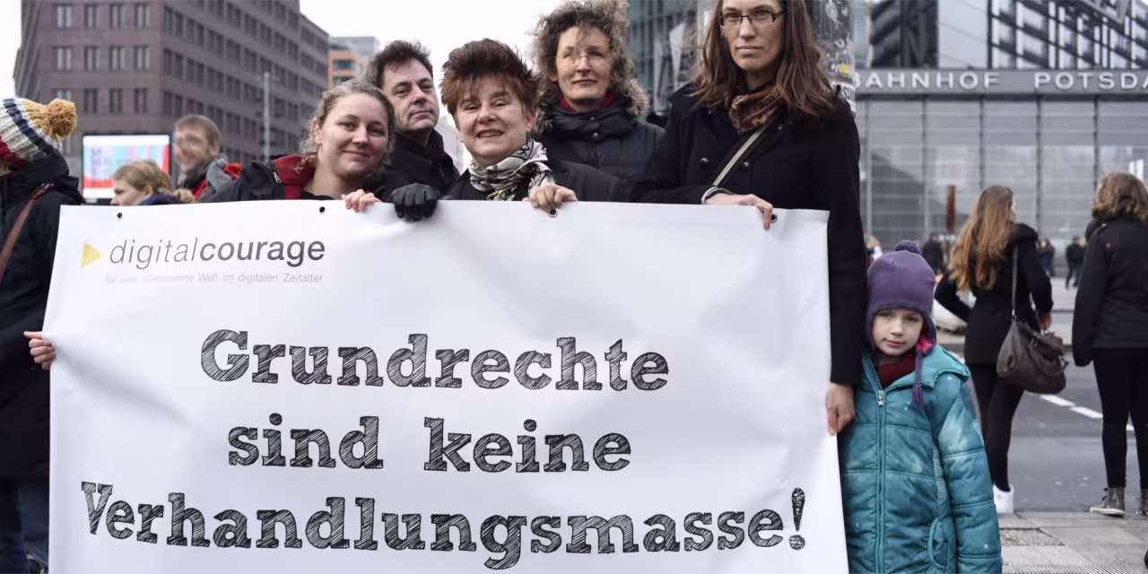 Ein Teil des Digitalcourage-Teams mit einem Banner: „Grundrechte sind keine Verhandlungsmasse!“