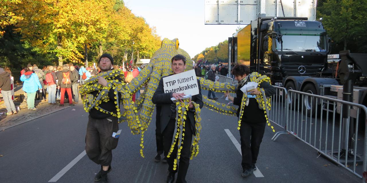 Demonstrant.innen tragen die Datenkrake. Auf einem Schild steht: "TTIP füttert Datenkraken".