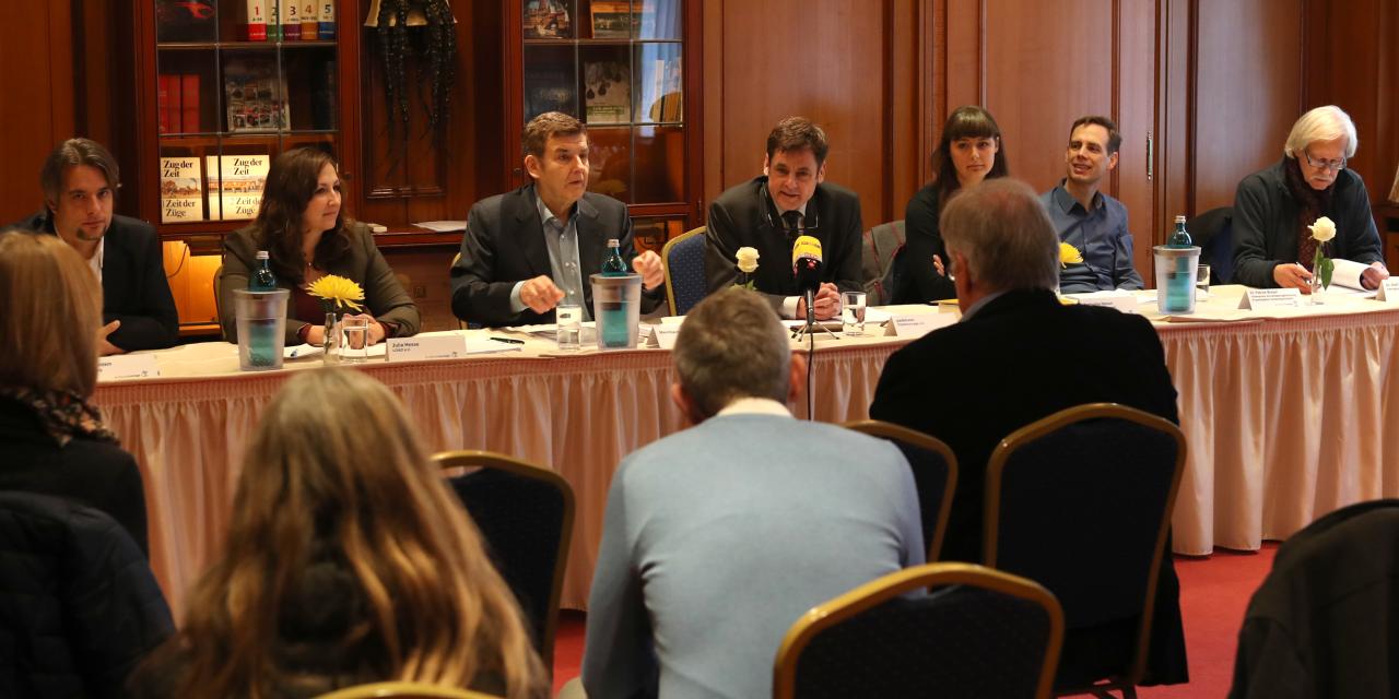 padeluun und andere Personen an einem langen Tisch mit Mikrofonen.