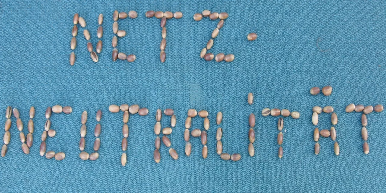 Das Wort „Netzneutralität“ aus Eicheln gelegt (auf blauem Grund).