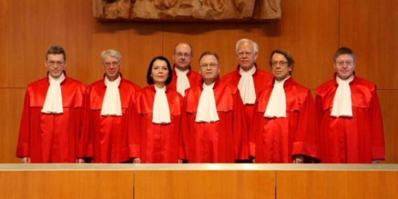 Acht Richter.innen des Bundesverfassungsgerichts in roten Roben.