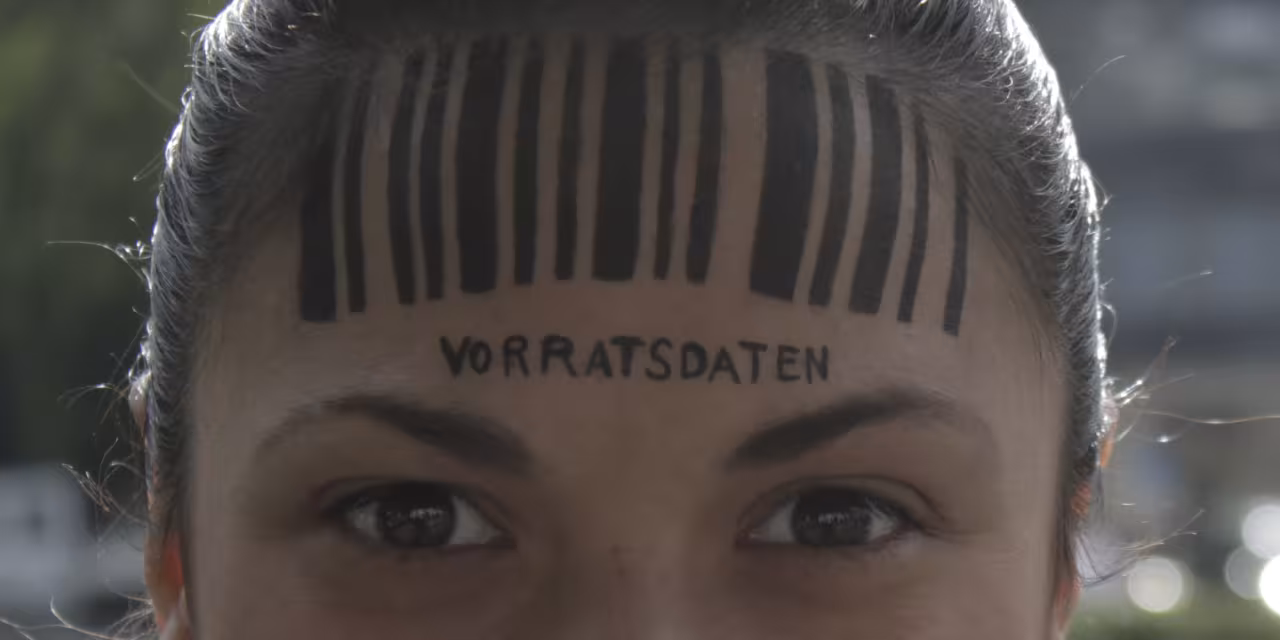 Detailaufnahme vom Kopf einer Person. Auf der Stirn ein Barcode. Darunter steht „Vorratsdatenspeicherung“.