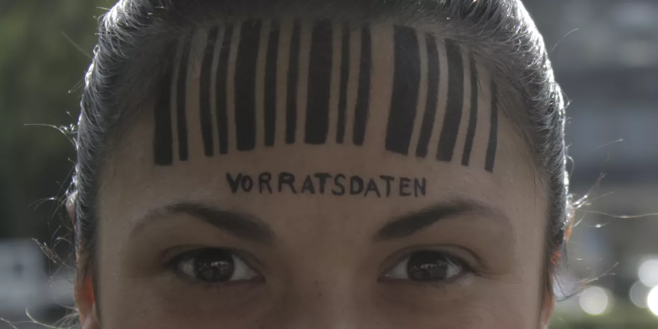 Detailaufnahme vom Kopf einer Person. Auf der Stirn ein Barcode. Darunter steht „Vorratsdatenspeicherung“.