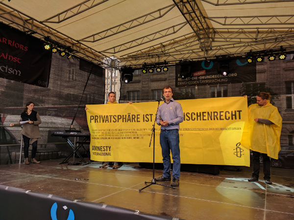 Mario Lenhart von Amnesty Deutschland auf der Redner.innenbühne. 